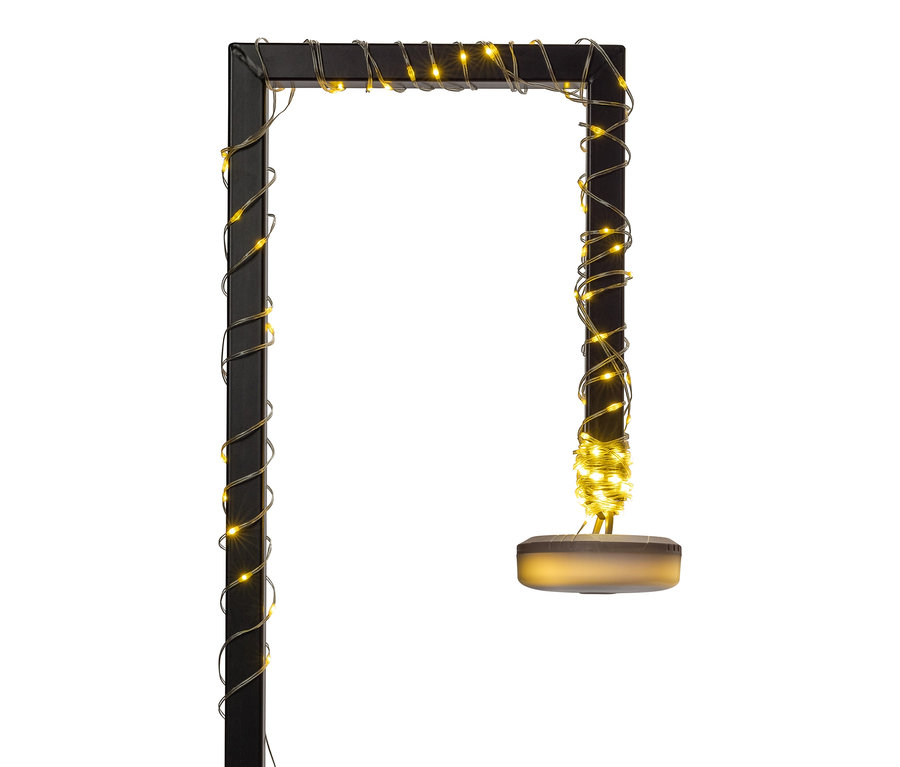 Eine schwarze, rechteckige Stehlampe ist mit warmweißen Lichterketten umwickelt.