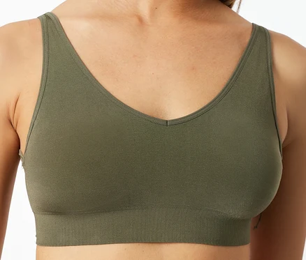Nahaufnahme einer Frau in einem olivgrünen SCHIESSER Soft-BH mit Pads, V-Ausschnitt und geripptem Unterbrustband.