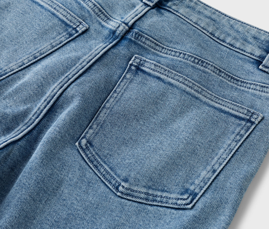 Detailansicht der Rückseite einer hellblauen Jeans mit Gesäßtaschen.