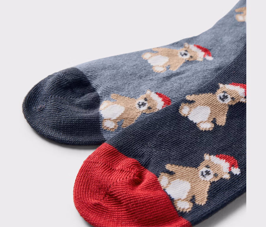 Detailaufnahme von zwei Paar Weihnachtssocken mit Bären mit Mützen.