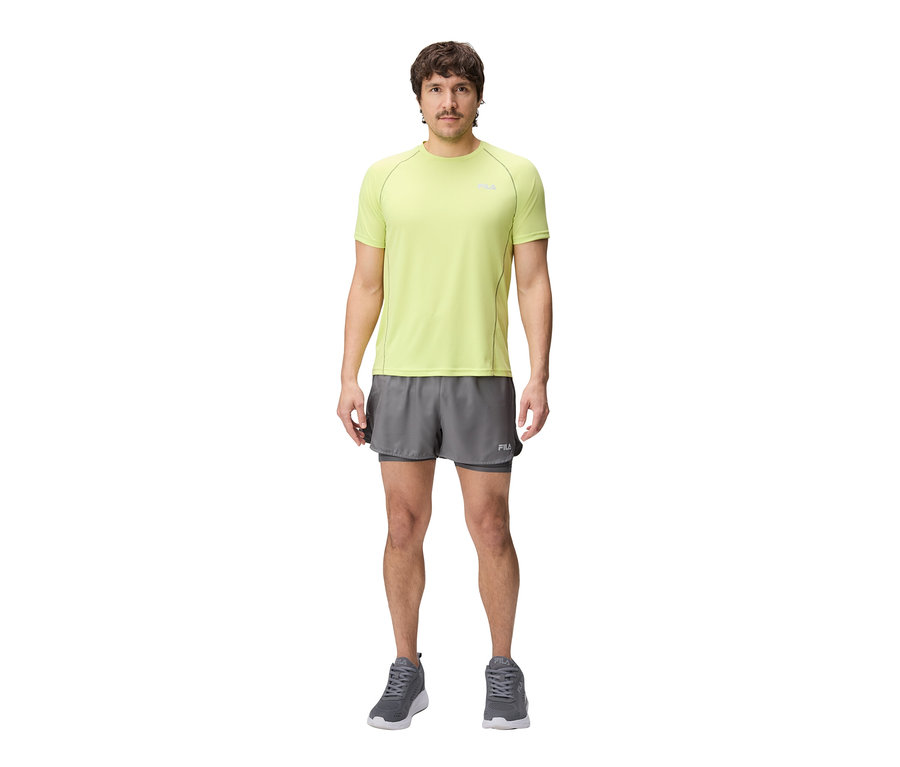 Mann trägt ein limegrünes FILA Herren-Funktionsshirt, graue Shorts und graue Turnschuhe.