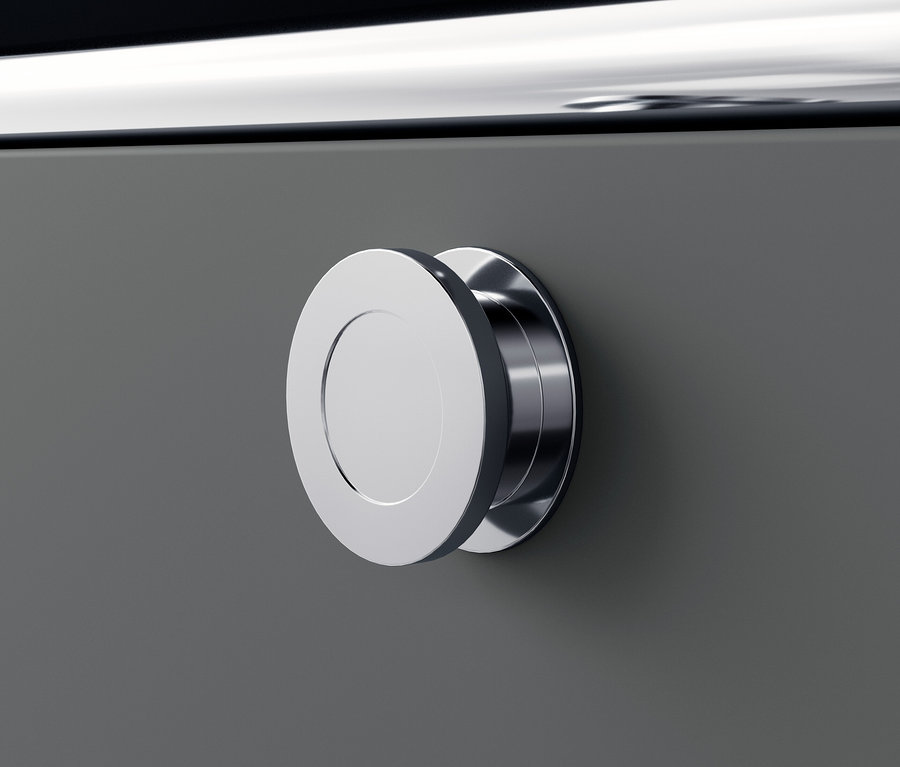 Detail einer grauen Metallkommode »CN3« mit rundem silbernem Griff.