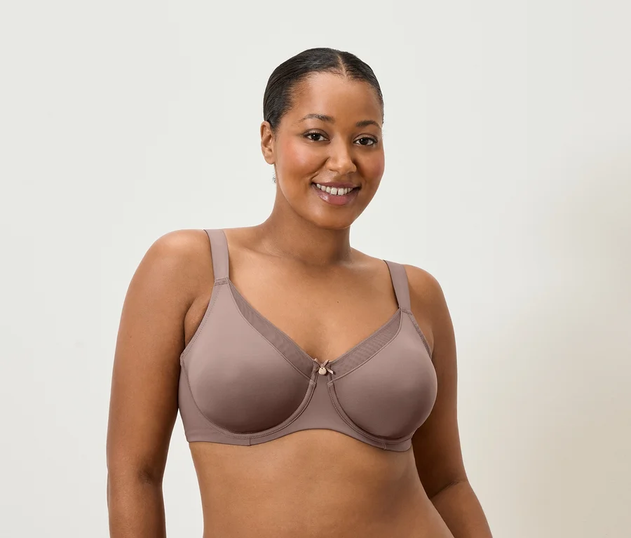 Frau lächelt und trägt einen BH in Mauve.
