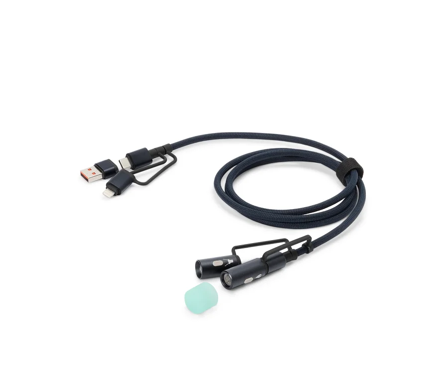 Ein blaues Ladekabel mit USB-, USB-C- und Lightning-Anschlüssen sowie zwei kleinen LED-Leuchten und einem Silikonaufsatz liegt auf einem weißen Hintergrund.