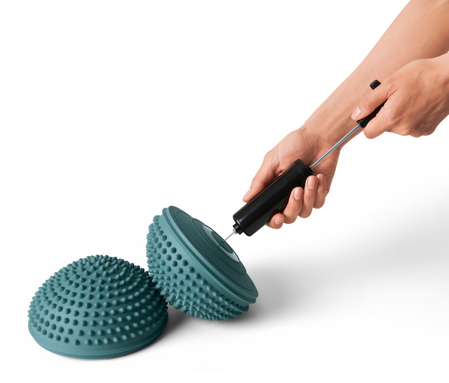 Eine Person pumpt mit einer Pumpe ein Balance-Pad aus dem 2er Set auf.