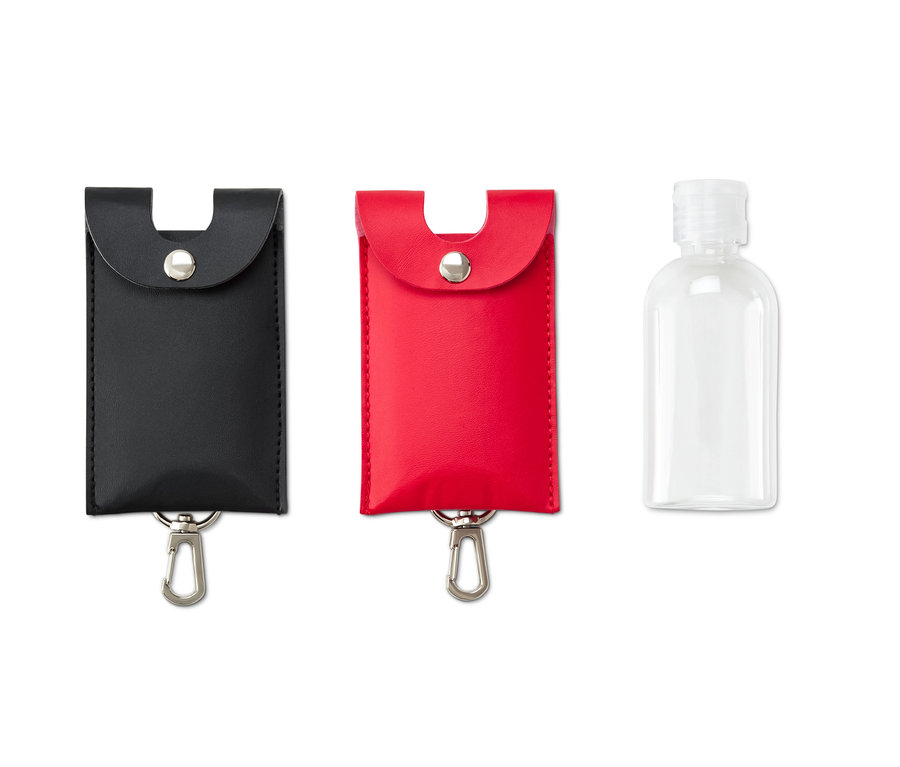 Zwei Desinfektionsmittel-Cover und eine leere Flasche. Ein Cover ist schwarz, das andere rot.