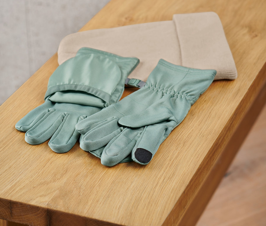 Ein Paar Klapp-Laufhandschuhe liegen auf einer Holzbank.