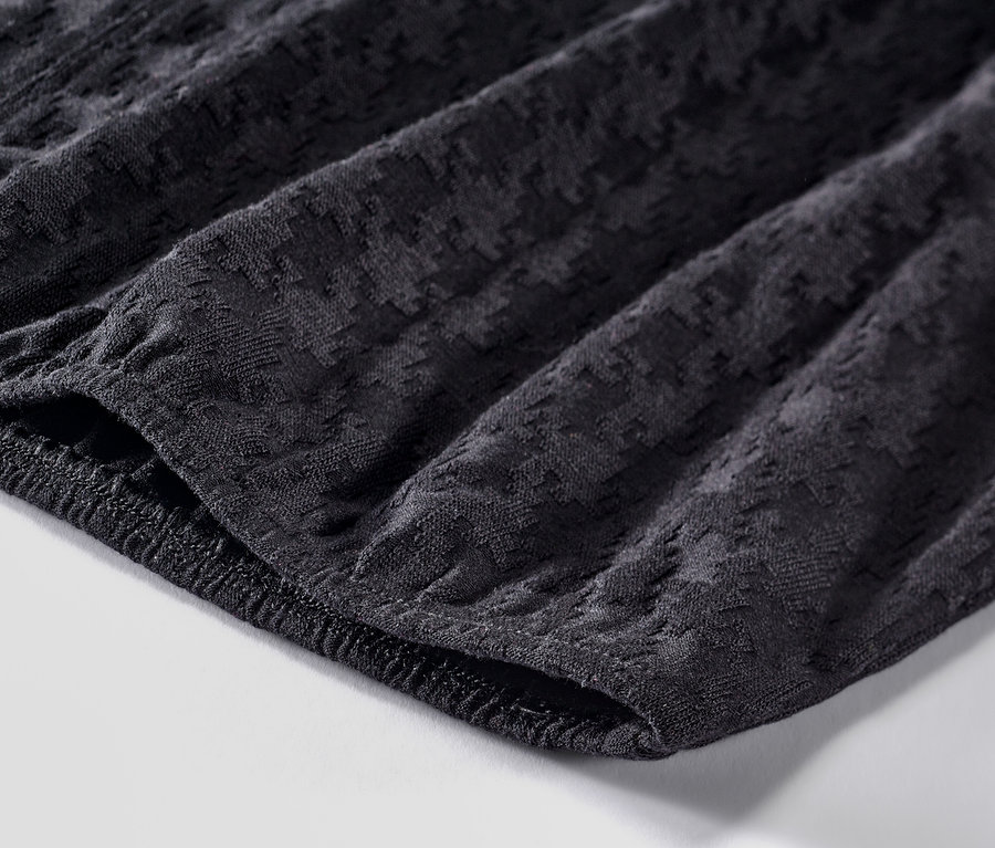 Detailansicht eines strukturierten, schwarzen Langarmshirts.