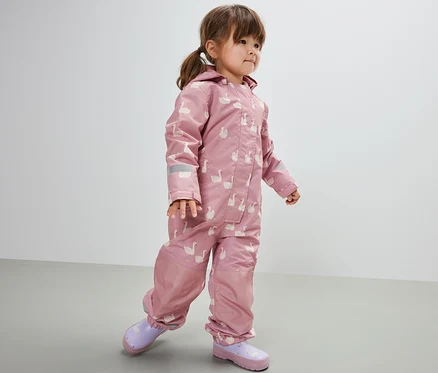 Mädchen trägt einen Kinder-Regen-Einteiler, Schwan. Sie trägt dazu lila Gummistiefel.