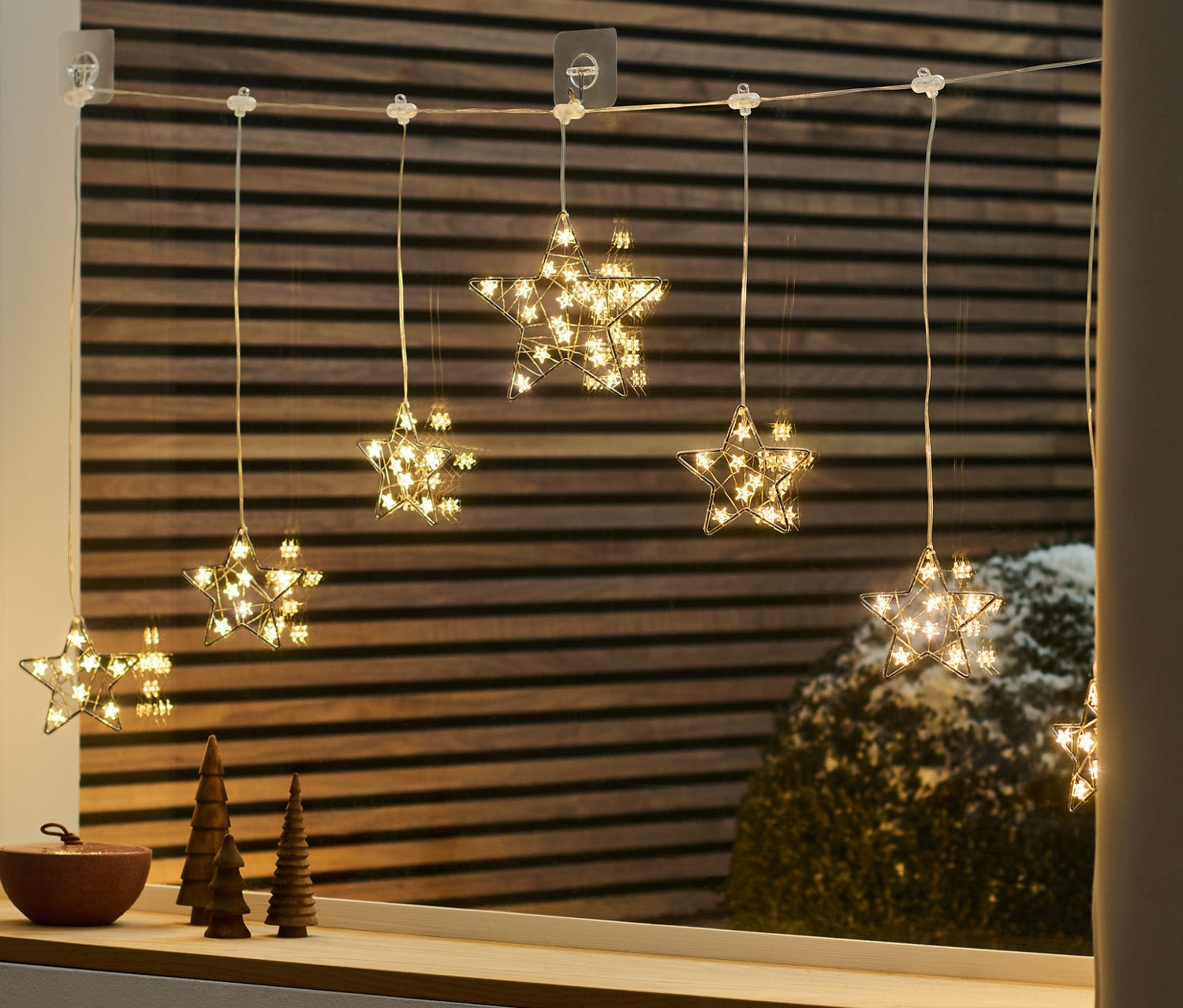 LED-Lichtvorhang in Sternform hängt am Fenster.