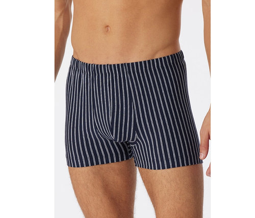 Mann trägt dunkelblaue SCHIESSER Shorts mit Bio-Baumwolle und weißen Längsstreifen, Oberkörper und Oberschenkel sind sichtbar.
