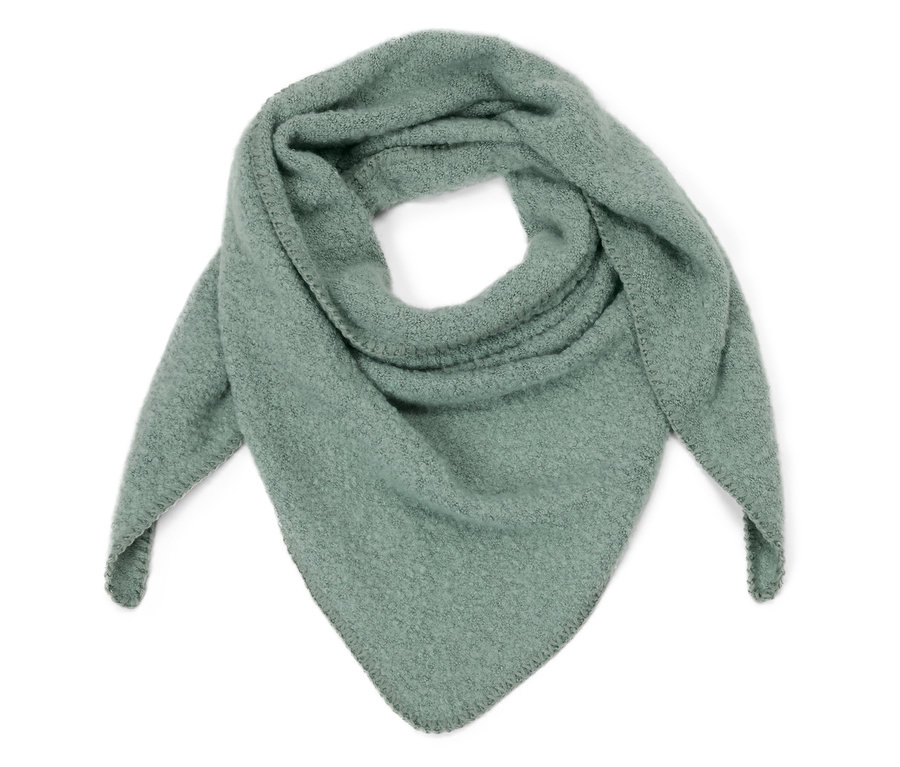 Ein hellgrüner Dreiecksschal in Boucléoptik liegt auf einem weißen Hintergrund.