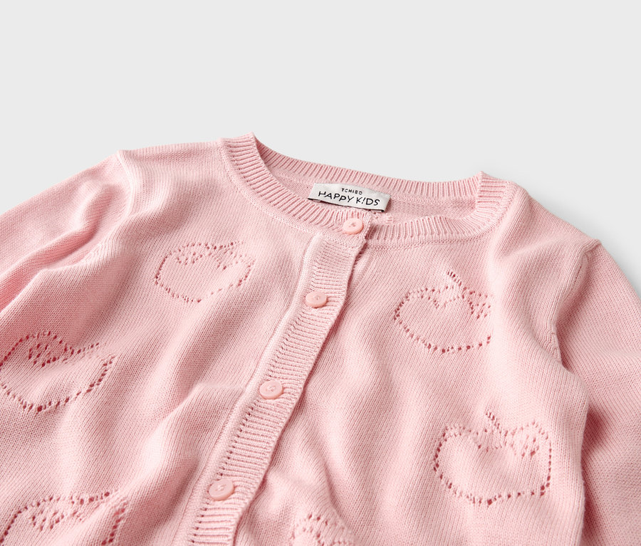Nahaufnahme einer rosa Strickjacke mit Apfelmuster.