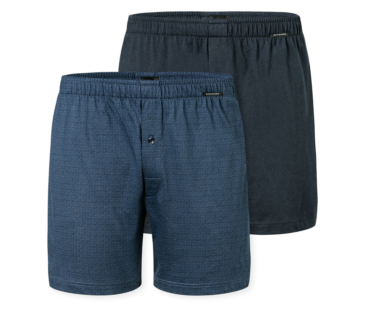 Zwei SCHIESSER Boxershorts, eine blau gemustert mit Knopf, eine dunkelblau, liegen übereinander.
