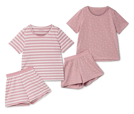 Zwei kurze Kinder-Pyjamas, einmal gestreift und einmal gepunktet, liegen nebeneinander.