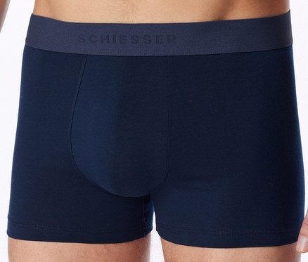 Mann trägt dunkelblaue Boxershorts mit SCHIESSER-Schriftzug am Bund.