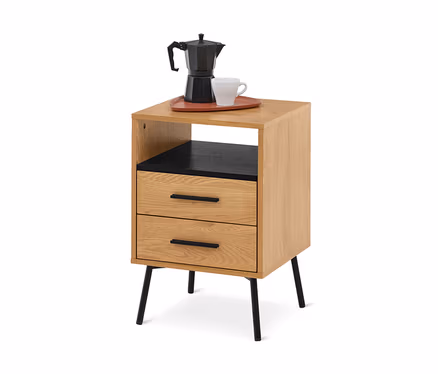 Nachttisch aus hellem Holz mit zwei Schubladen und einem offenen Fach, schwarzen Beinen und schwarzen Schubladengriffen. Eine schwarze Mokkakanne und eine weiße Tasse stehen auf einem rotbraunen Tablett darauf.