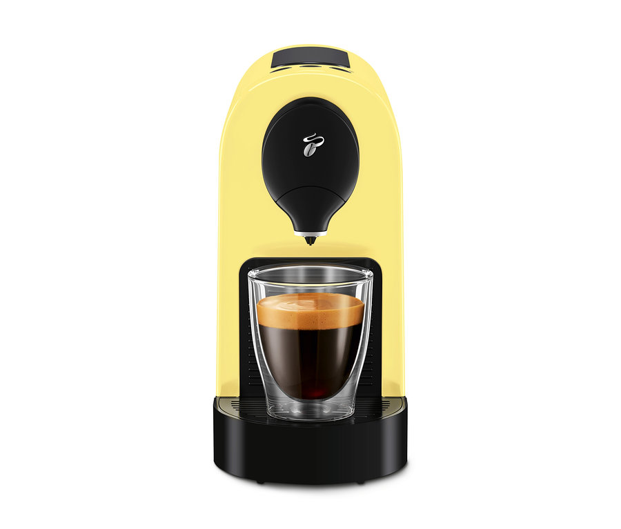Gelbe Kaffeemaschine mit einer Tasse Kaffee.