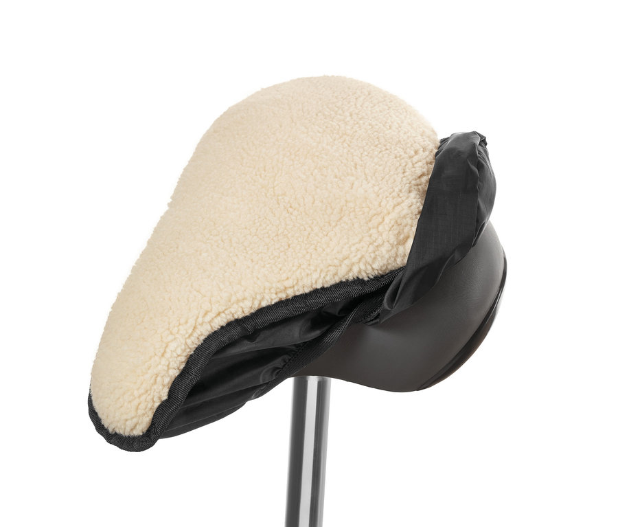 Nahaufnahme eines 2-in-1-Sattelbezugs mit beigem Teddyfell und schwarzem Nylonrand.