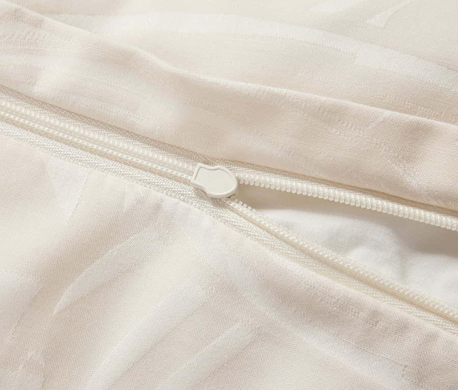 Detailaufnahme eines weißen Bettbezugs mit Reißverschluss.