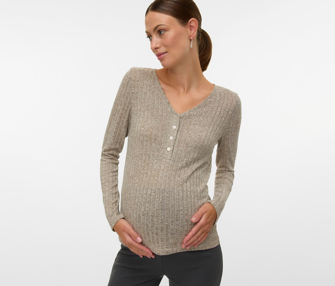 Schwangere Frau mit MAMALICIOUS Shirt »MLPAMMIE LIA« mit langen Ärmeln und Knöpfen, die ihren Bauch hält.