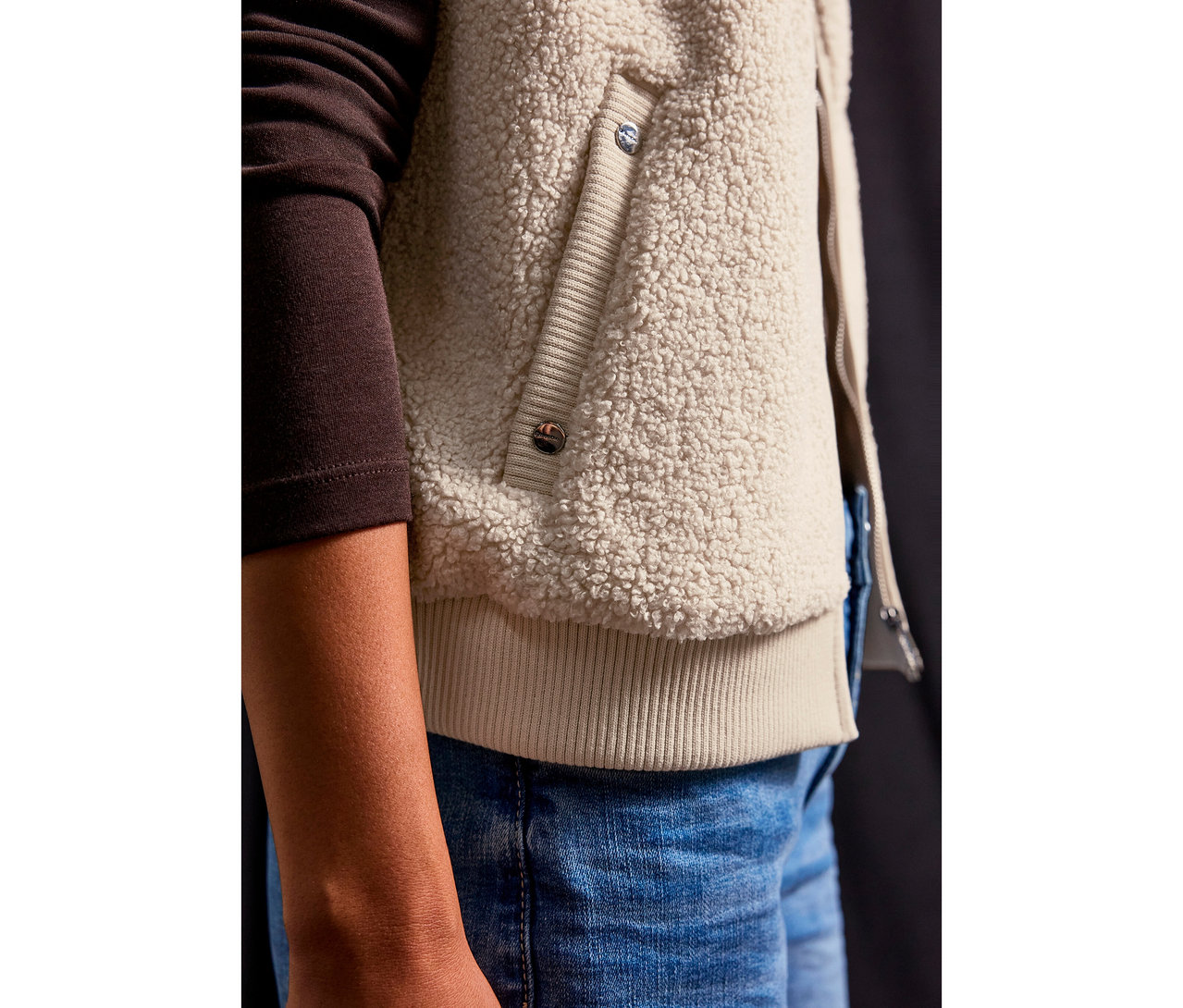 Nahaufnahme einer Person, die eine Street One Teddyweste und Jeans trägt.