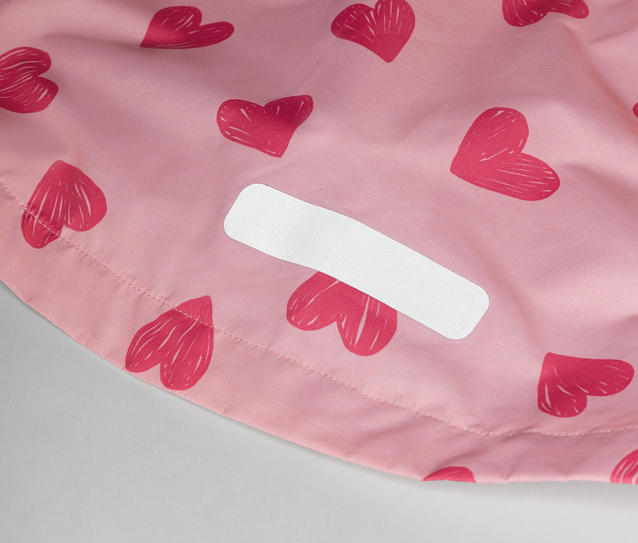 Nahaufnahme eines rosafarbenen Stoffes mit Herzmuster und einem weißen Etikett.