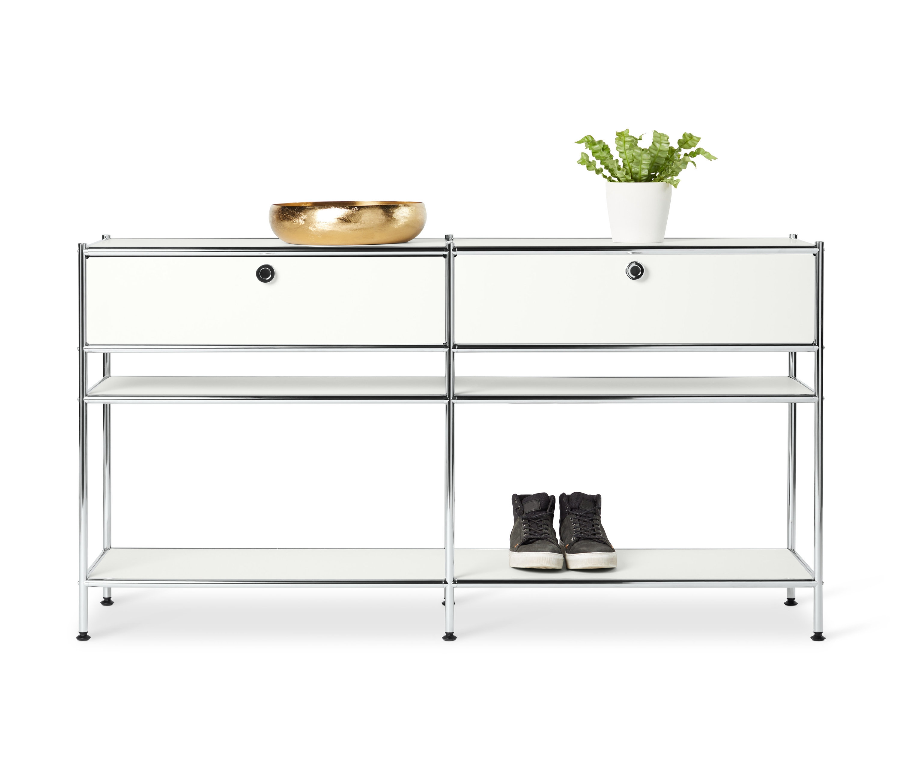 Zwei weiße Metallkonsolen »CN3« mit je 2 Schubladen stehen nebeneinander. Auf der Oberseite der linken Konsole steht eine goldene Schale und auf der Oberseite der rechten Konsole eine Pflanze in einem weißen Topf. Im unteren Regal stehen Schuhe.