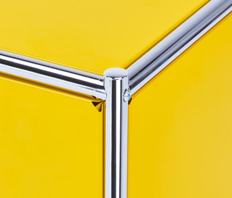 Detailansicht eines gelben »CN3« Metall-Lowboards mit verchromtem Rohrrahmen.