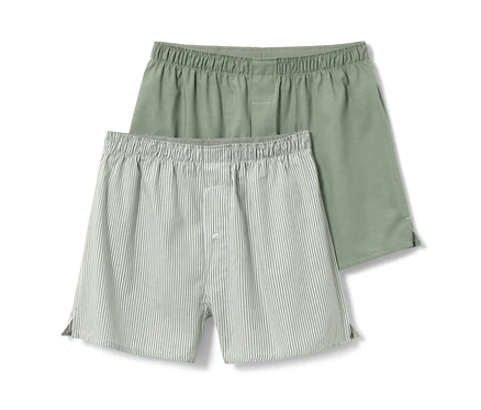 Zwei Webboxershorts, eine einfarbig grün, die andere gestreift.