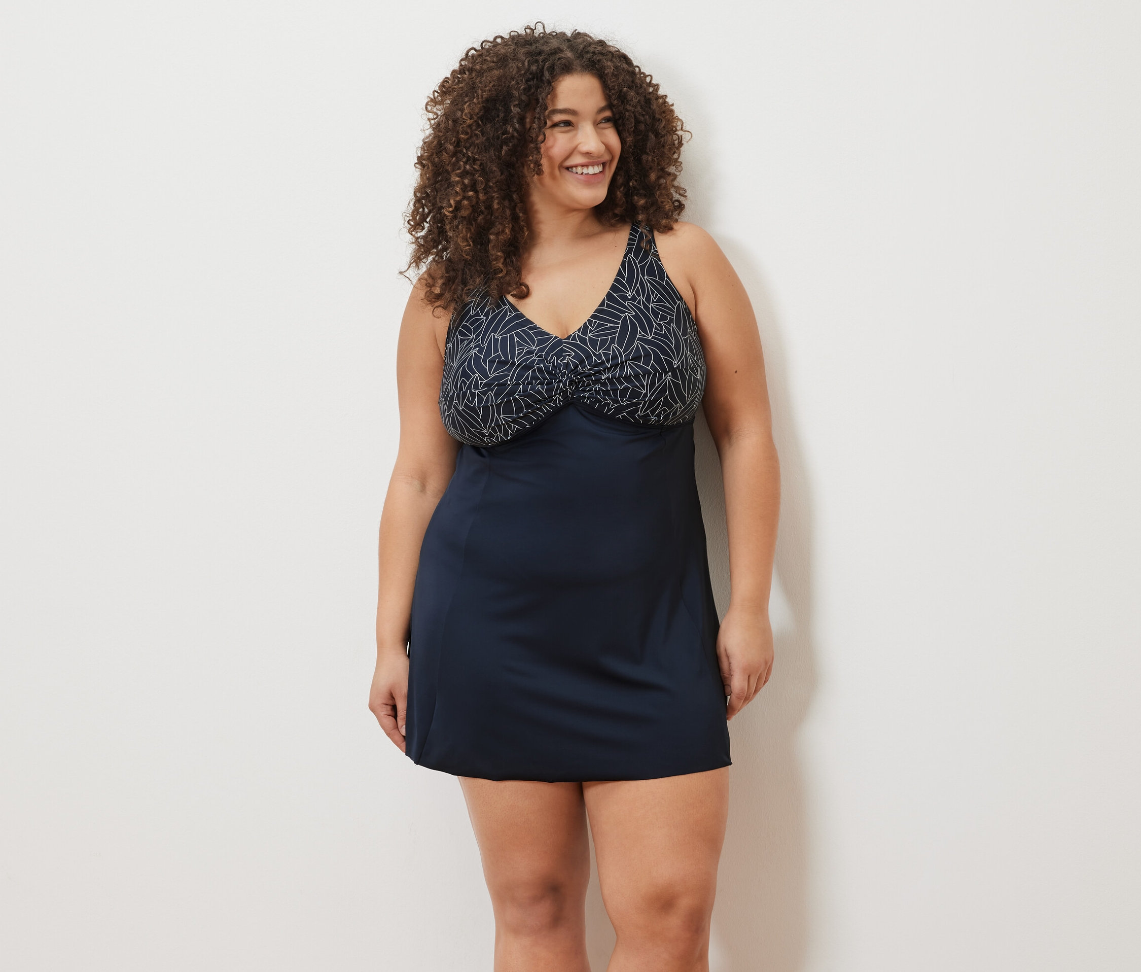 Frau lächelt und trägt ein Badekleid.