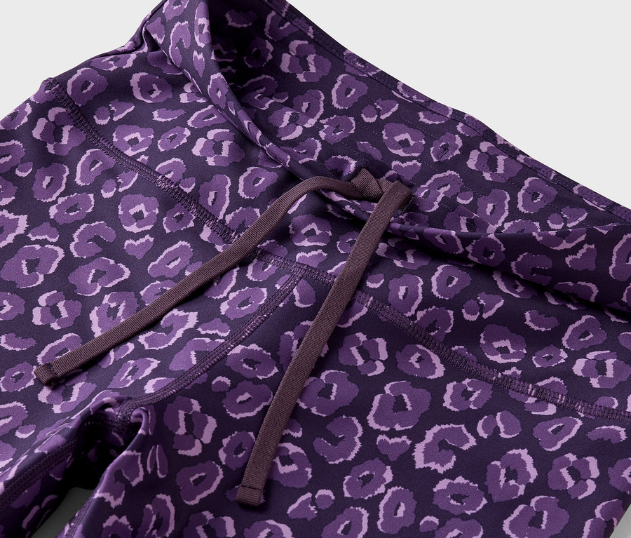 Detailaufnahme von lila Leggings mit Tiermuster und braunem Kordelzug in der Taille.