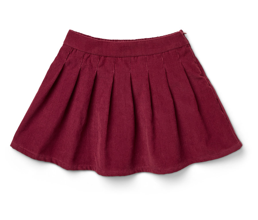 Ein burgunderroter Faltenrock aus Cord liegt auf einem weißen Hintergrund.