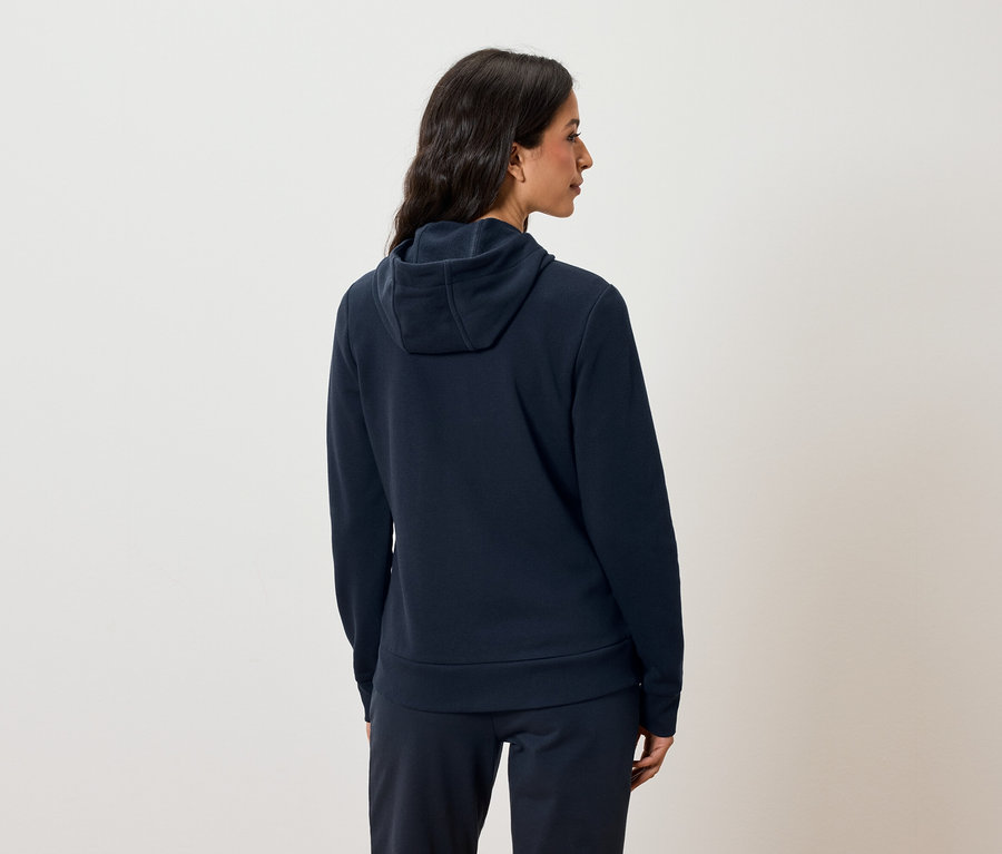 Frau von hinten trägt einen marineblauen Hoodie und eine Jogginghose.