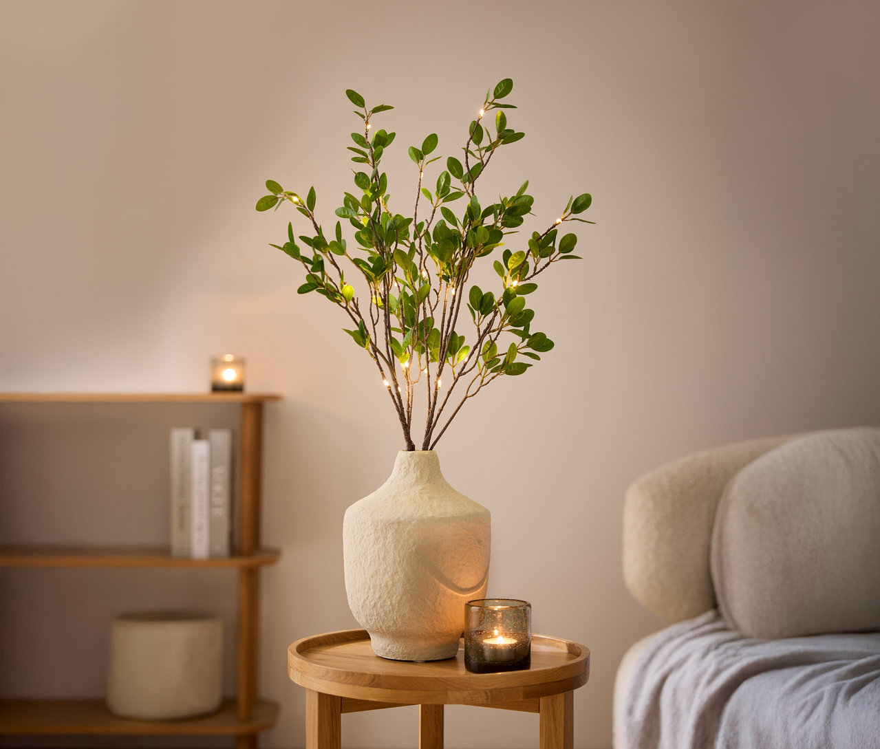Zwei LED-Dekozweige in einer weißen Vase auf einem Holztisch.