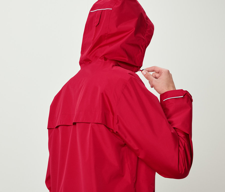 Mann in roter Jacke justiert die Kapuze.