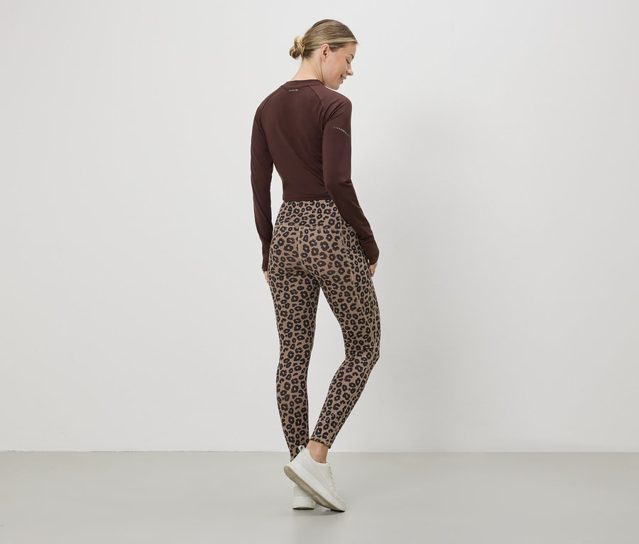 Eine Frau von hinten, mit braunem Oberteil, Leggings mit Leopardenmuster und weißen Turnschuhen.