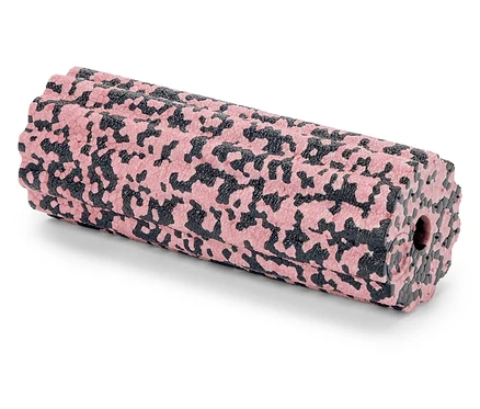 Eine rosa-schwarze gemusterte Faszienrolle liegt auf einer weißen Oberfläche.