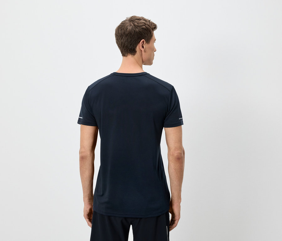 Ein Mann von hinten trägt ein marineblaues T-Shirt und schwarze Shorts vor einem weißen Hintergrund.