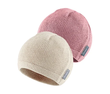 Zwei gestrickte Babyhauben, eine rosafarbene leicht hinter einer hellbeigen positioniert. Beide haben ein kleines Markenetikett.