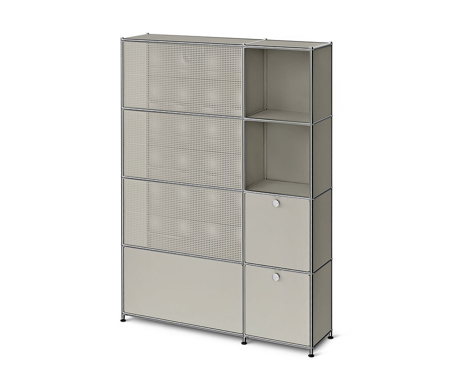 Graues, modulares Aufbewahrungsmöbel mit Chromrahmen. Links drei perforierte Türen und eine geschlossene Tür unten, rechts zwei offene Fächer und zwei geschlossene Türen mit runden Griffen.
