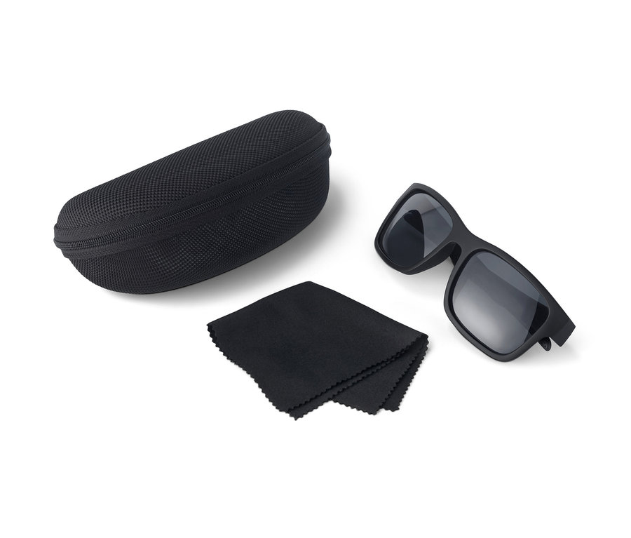 Schwimmfähige Sonnenbrille, Etui und Putztuch in Schwarz vor weissem Hintergrund.