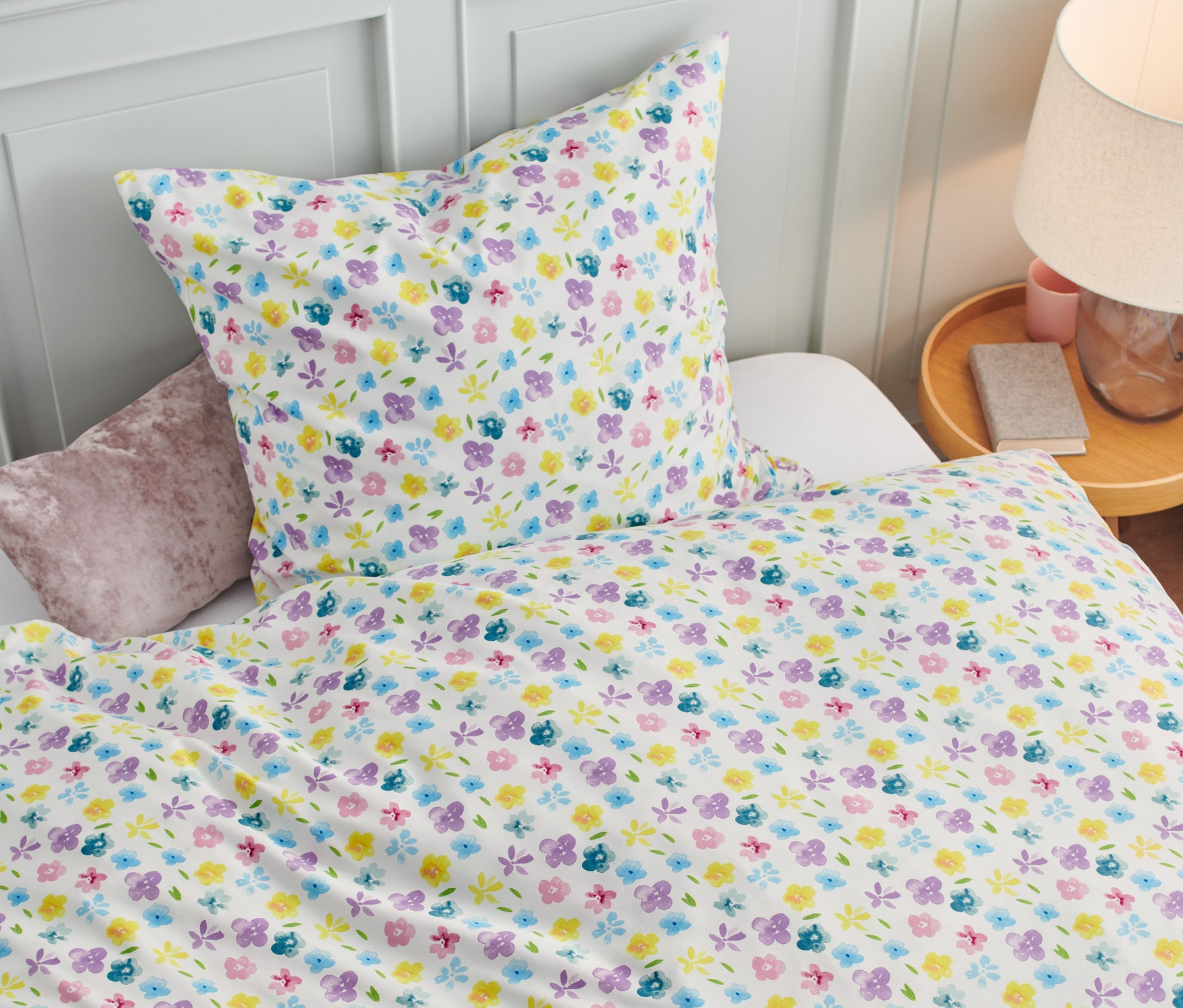 Blumige Microfaser-Bettwäsche Normalgröße auf einem Bett.