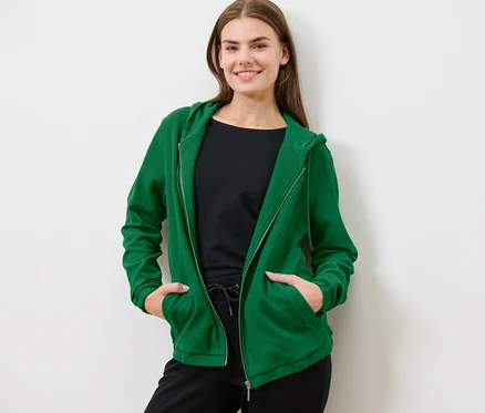 Frau posiert in grüner Sweatjacke.
