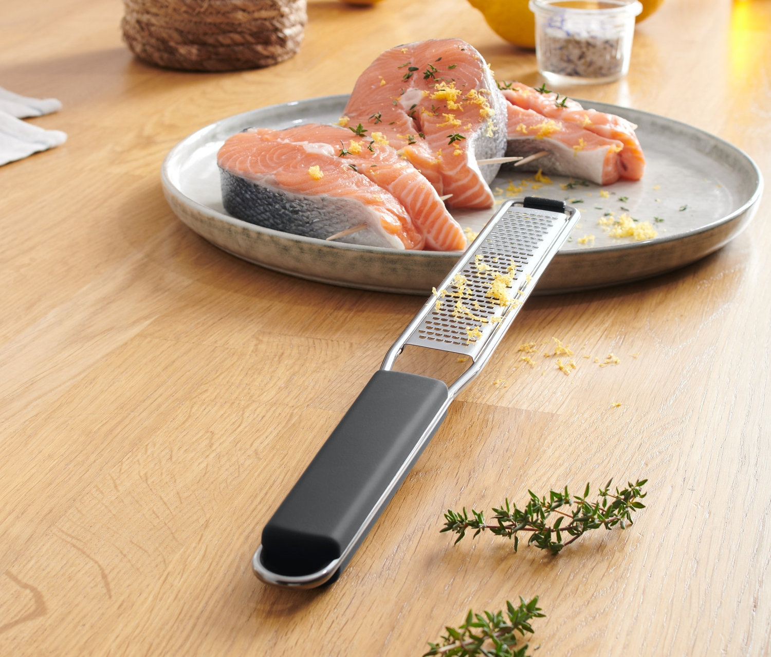 Zwei Lachsscheiben auf einem Teller mit Handreibe, fein.