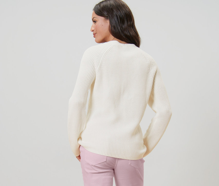 Frau von hinten trägt einen cremefarbenen Strickpullover.