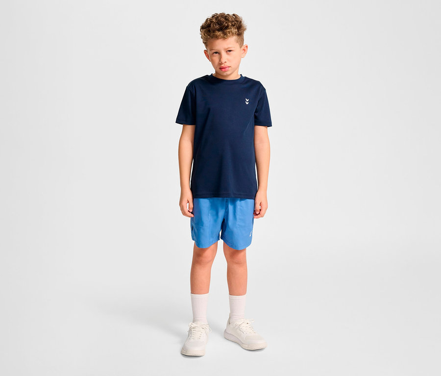 Junge trägt blaue Shorts und dunkelblaues HUMMEL HMLJR pulse Training-T-Shirt.