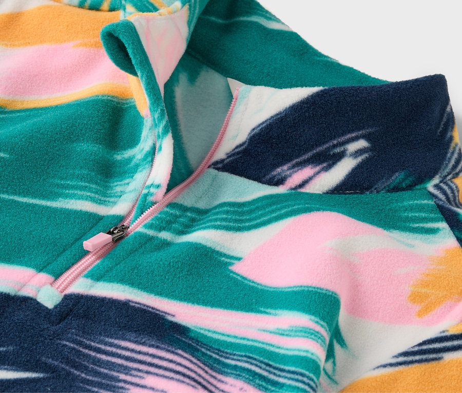 Detailaufnahme eines gemusterten Fleecepullovers mit kurzem Reißverschluss.