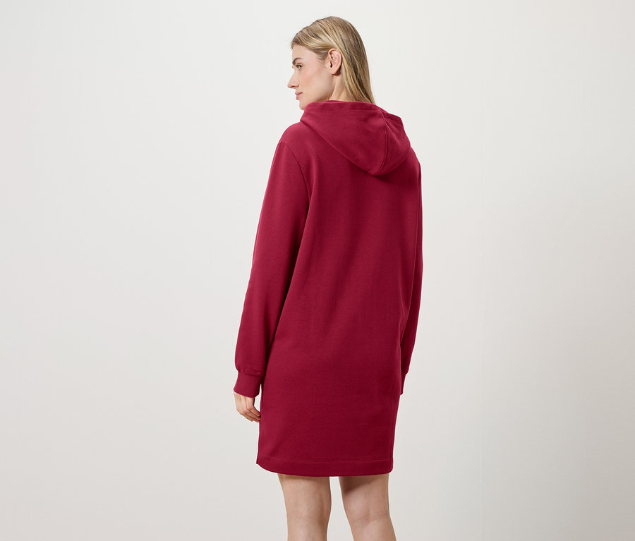 Eine Frau mit dem Rücken zur Kamera trägt ein rotes Kapuzenkleid.