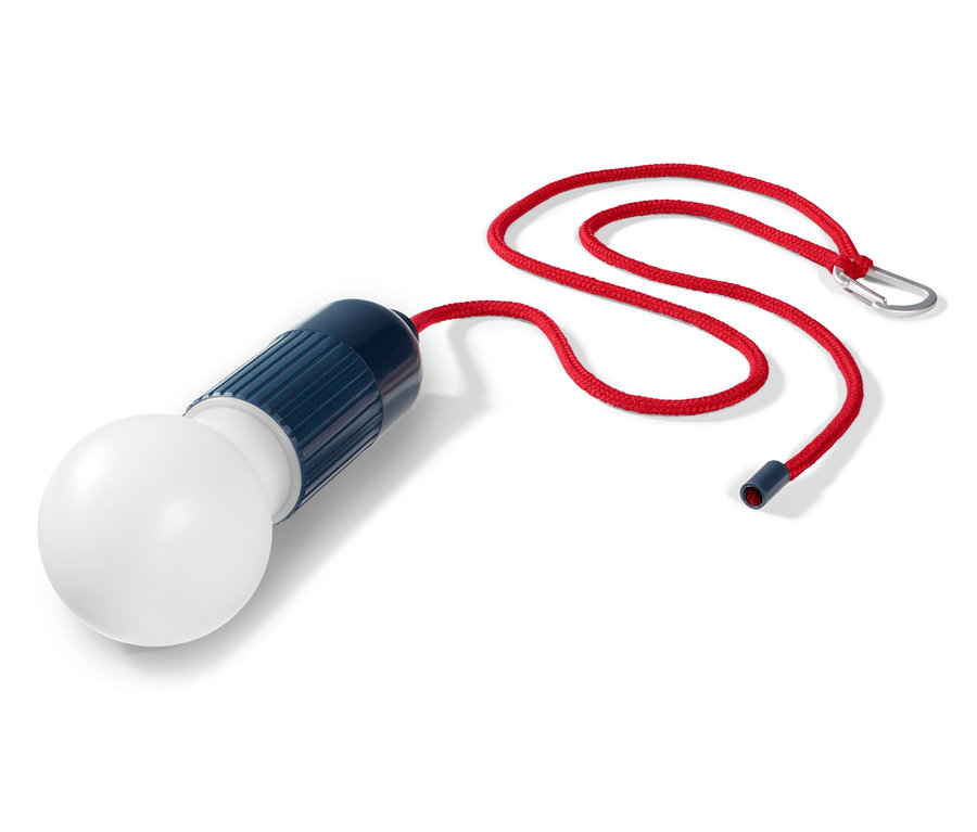 Eine LED-Lampe mit Karabiner liegt auf einem weißen Hintergrund.